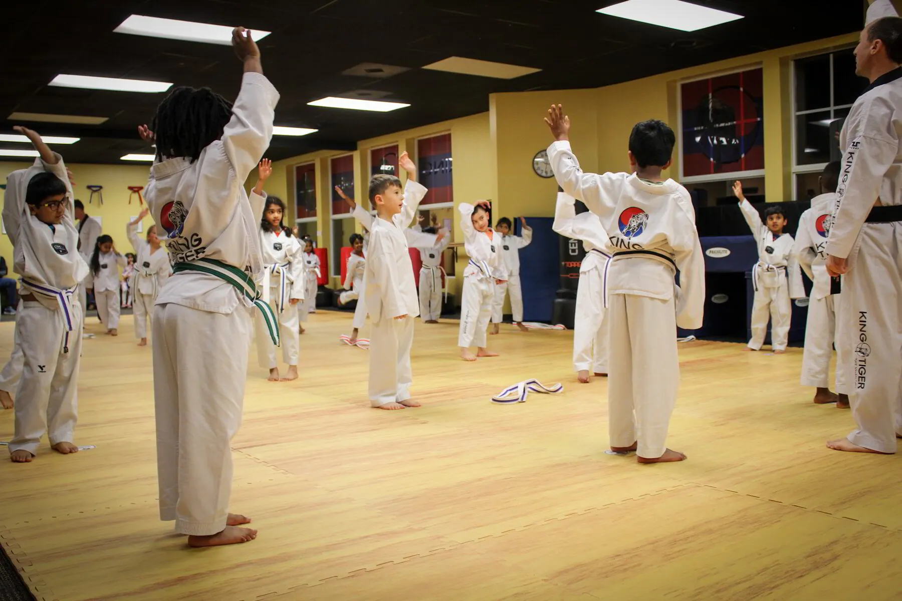 Young students raising their hands during a lively King Tiger class